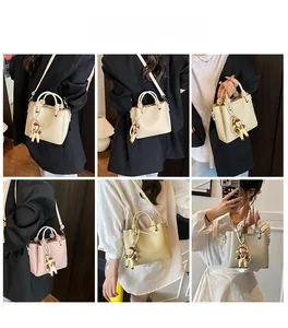 Bolso bandolera con diseño de lichi en varios colores mostrado con modelo en rejilla
