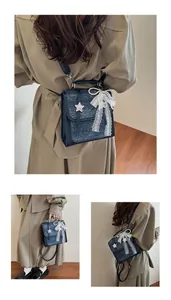 Detail of dark blue tweed handbag with lace bow, pearls and star pendant charm