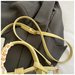 Détail du sac seau crème avec poignée en foulard et bandoulière réglable