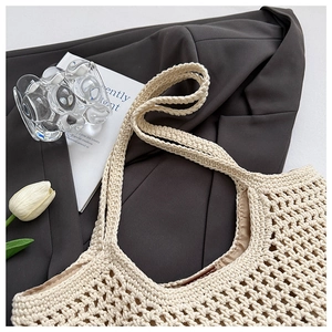 Détail du sac fourre-tout au crochet avec doublure posé sur un blazer gris