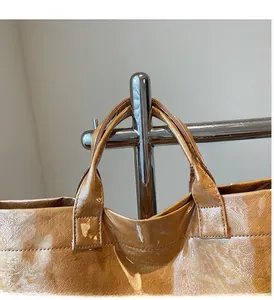 Close-up of brown tote bag with water ripple texture and durable handle detail