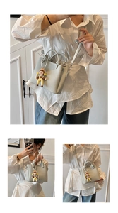 Detalle del bolso de cubo en cuero azul claro con asa anudada y colgante de muñeca
