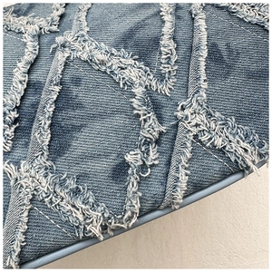 Détail macro du patchwork de denim bleu avec bords effilochés et texture matelassée