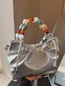 Silver metallic pleated bucket bag with colorful acrylic beaded handle and drawstring closure
