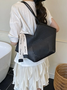 Large black perforated leather tote bag with long straps for women's daily commute