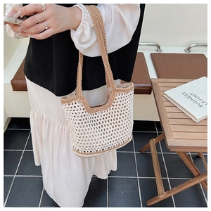 Détail de la maille évidée et des finitions marron d'un sac cabas en maille tressée