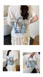 Detail of light blue PVC bucket bag with silk scarf handle and golden metal clasp