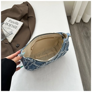Vue détaillée de l'intérieur du sac en denim matelassé avec doublure beige et poche zippée