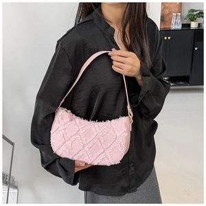 Détail du sac à main en denim rose matelassé avec texture effilochée et coutures