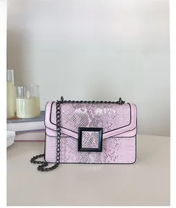 Détail du sac bandoulière rose à motif serpent avec boucle noire mate et bandoulière chaîne