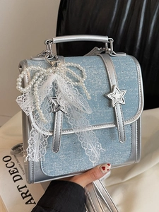 Chic light blue denim handbag with silver trim and elegant pearl lace bow accessory