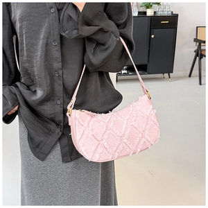Gros plan du sac baguette en jean rose avec texture matelassée à bords effilochés