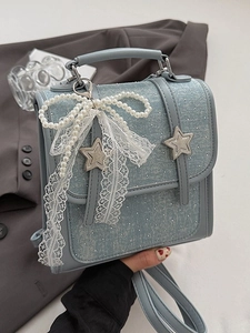 Light blue denim handbag with white polka dots, pearls, and lace bow decoration