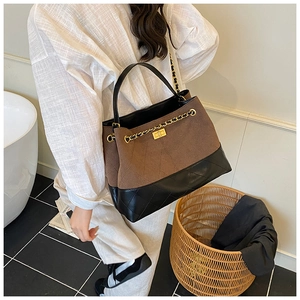 Brown frosted retro shoulder bag with stitching and gold chain detail on model