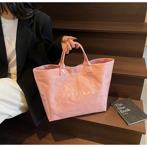 Detail view of pink wrinkled PVC tote bag showing large capacity and TOTE BAG print
