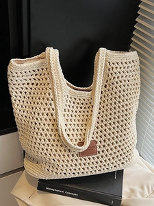 Grand sac cabas tissé ajouré beige avec écusson en cuir marron sur fond de lin blanc