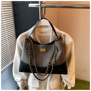 Detail of color-block quilted chain bag with grey suede, black leather and gold clasp