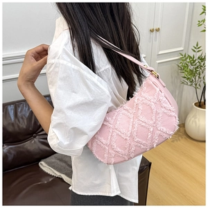 Détail du sac en denim rose avec motif losange effiloché et bandoulière en cuir