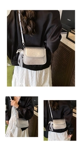 Macro detail of silver pleated crossbody bag featuring lace and pearl decorative charms