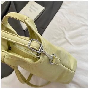 Gros plan sur un sac cabas jaune à motif crocodile avec zip argenté et boucles en métal