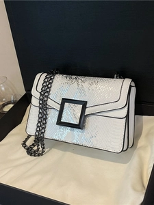 Sac bandoulière blanc motif serpent avec boucle noire et chaîne dans un coffret