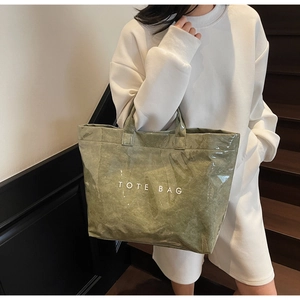 Detail of moss green tote bag with crinkled texture and transparent waterproof coating