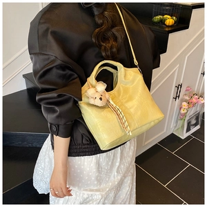 Détail du sac cabas vert clair avec motif crocodile et charmant petit ours en peluche
