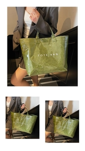 Detail view of glossy olive green waterproof tote bag with white text on stairs