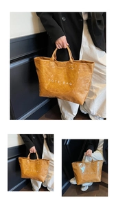 Detail view of brown glossy tote bag with white Tote Bag text and wrinkled texture finish
