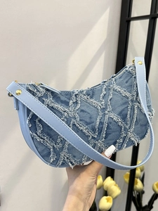 Sac hobo en denim patchwork avec coutures effilochées et détails de rivets dorés