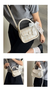 Detail of elegant small beige crossbody bag with lace bow and stylish top handle