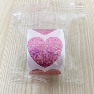 Vista dettagliata di adesivi laser olografici a forma di cuore in confezione di plastica