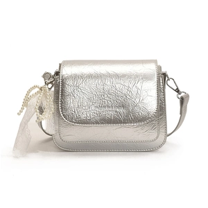 Silver metallic crossbody bag with pleated texture and pearl lace charm on white background