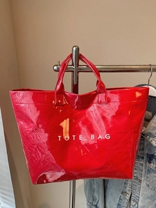 Minimalist red PVC tote bag with high-gloss finish and white TOTE BAG print