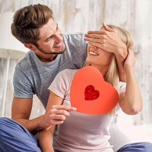 Dettaglio della bacchetta decorativa a cuore rosso glitterato tenuta da una coppia