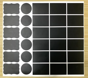 Macro view of 30-piece waterproof black chalkboard stickers in various shapes on wood