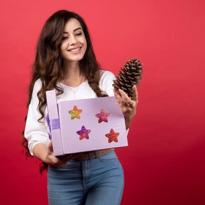 Laser star stickers on light purple gift box with ribbon decoration on red background