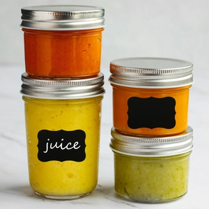 Waterproof PVC chalkboard labels on glass jars with metal lids and juice contents