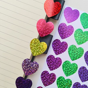 Macro detail of multicolored glitter heart stickers for gift wrapping and DIY crafts