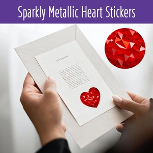 Detailed view of red sparkly metallic heart stickers used on wedding save the date cards