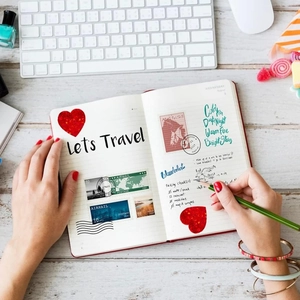Adesivi olografici a cuore e francobolli vintage che decorano un diario di viaggio