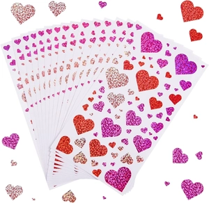 Dettaglio di adesivi a cuore glitterati in tonalità rosso e rosa per confezioni regalo