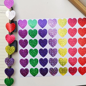 Detailed view of colorful heart glitter stickers applied on a notebook edge for decoration
