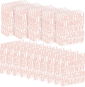 Macro detail of multi-page colorful alphabet and number stickers in peach tones