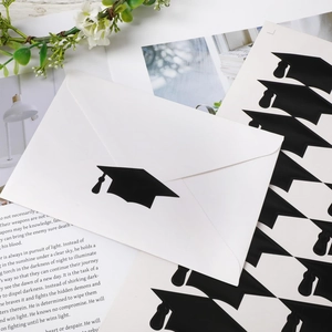 Macro detail of black graduation cap adhesive stickers on envelope with elegant book background