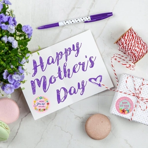 Macro shot of floral Mother's Day stickers on gift packaging with marble background