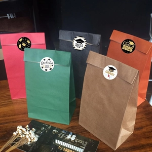 Colorful gift bags with 2025 graduation cap stickers on a rustic wooden table