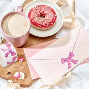 Close-up of pink glitter bow stickers roll on an elegant aesthetic afternoon tea table