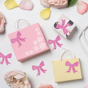 Detailed view of pink glitter bow stickers used for gift box packaging decoration