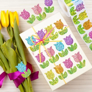 Roll of glitter tulip stickers in vibrant colors on a white gift box for decoration